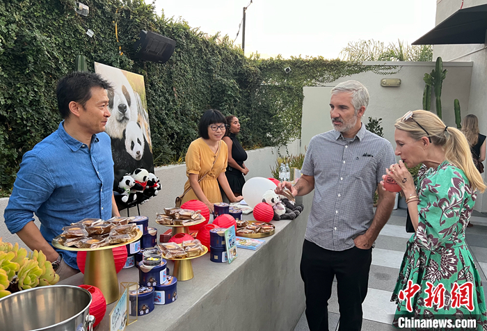 圖為中國(guó)駐洛杉磯旅游辦事處主任吳大偉（左一）向美國(guó)來賓介紹傳統(tǒng)的中秋佳節(jié)，邀請(qǐng)他們品嘗月餅。 <a target='_blank' href='/'>中新社</a>記者 張朔 攝