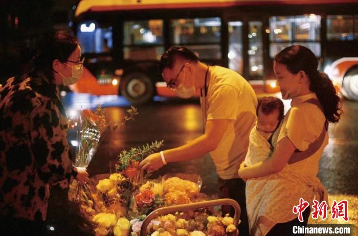 抱著襁褓中的孩子來買花的夫妻?！∈茉L者供圖