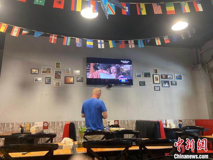 走進(jìn)店里，掛在天花板的各國國旗映入眼簾，電視中正播放著印度電影?！⒂駶?攝