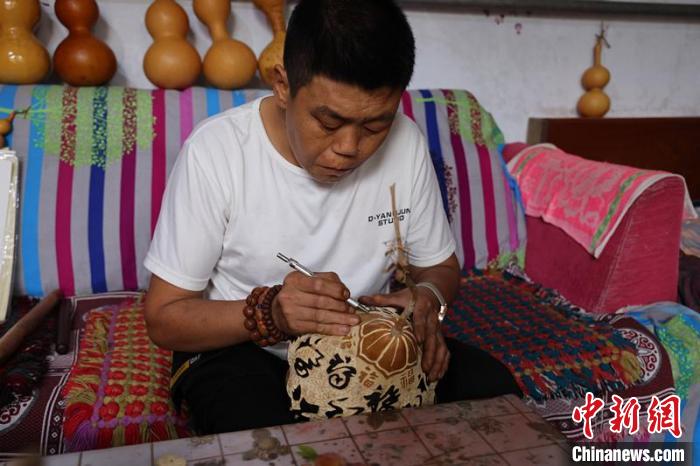 馮計(jì)剛在雕刻葫蘆作品。　孔飛 攝