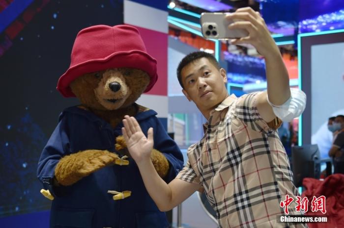 圖為觀眾在英國展臺和“帕丁頓熊”合影留念。中新網記者 李駿 攝