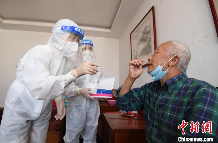 圖為貴陽市南明區(qū)望城街道的工作人員上門指導(dǎo)老年人進(jìn)行抗原檢測?！≮w松 攝