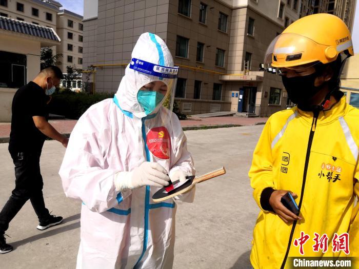 圖為母親袁素明在核酸檢測點(diǎn)登記?！』⑴_街道辦供圖