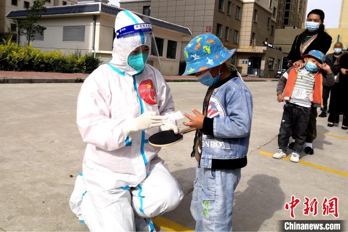 圖為母親袁素明在核酸檢測點(diǎn)登記?！』⑴_街道辦供圖