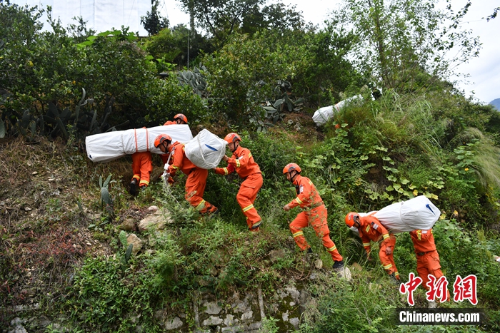 消防隊員背著帳篷上山。張浪 攝