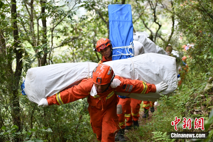 消防隊員背著帳篷上山。張浪 攝