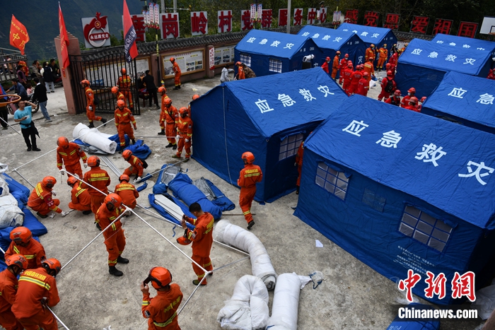 
消防隊員在磨崗嶺村搭建帳篷。張浪 攝
