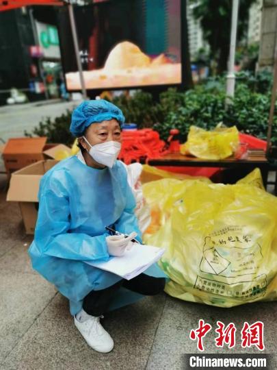 陳福珍在南明區(qū)花果園花中社區(qū)參與志愿工作登記醫(yī)療物資。　伍春華供圖