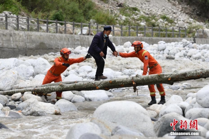 9月6日，四川甘孜州瀘定縣磨西鎮(zhèn)，甘孜州森林消防支隊(duì)康定中隊(duì)隊(duì)員在木橋旁護(hù)送村民。 <a target='_blank' href='/'>中新社</a>記者 張浪 攝