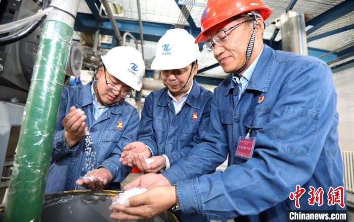 工作人員在粒料取樣口查看產(chǎn)品情況?！±钋?攝