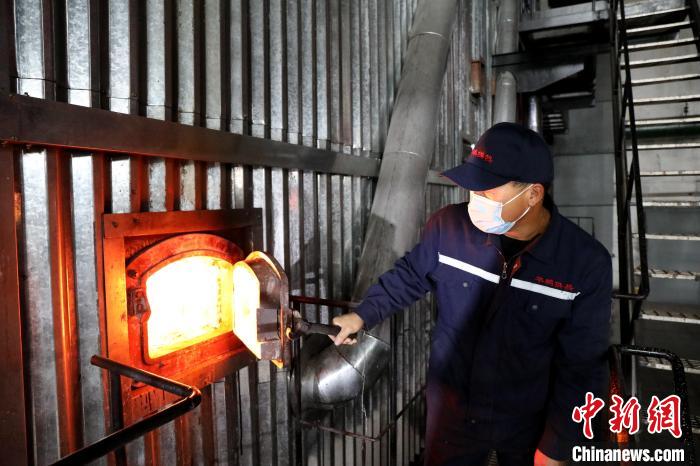 供熱工人查看供熱鍋爐燃燒情況?！∩厶炖?攝