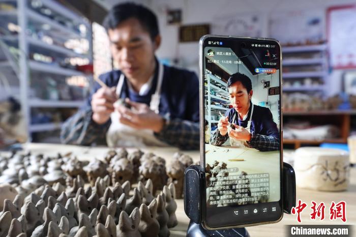 姚德波用直播方式給網(wǎng)友展示“桐梓泥哨”制作技藝。　瞿宏倫 攝