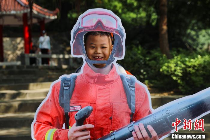 游客參與變身消防員活動。　李袁輝 攝