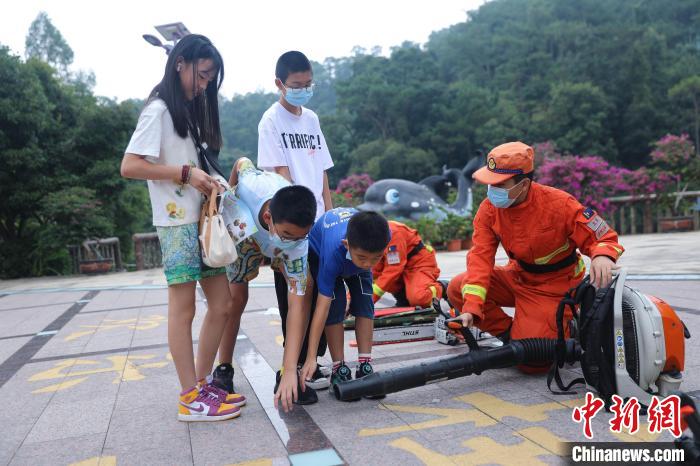 游客正在體驗滅火裝備?！±钤x 攝