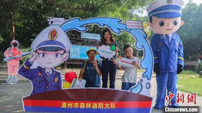 游客在防火打卡欄上合影?！±钤x 攝