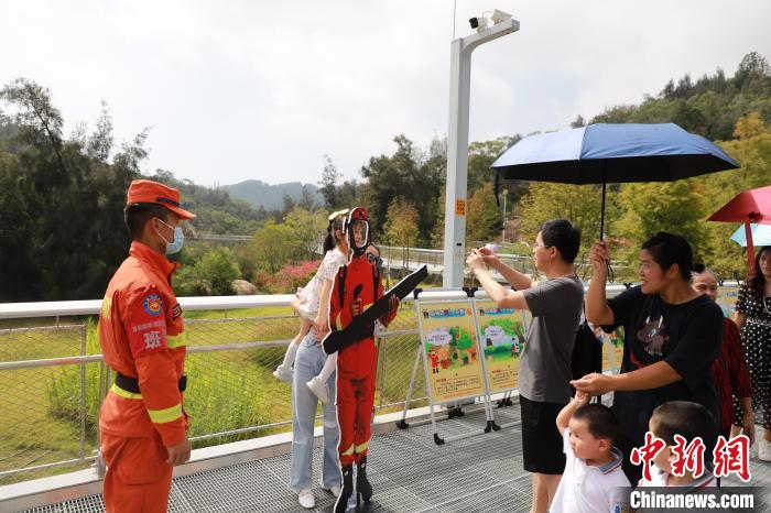 游客在森林消防戰(zhàn)斗員人物展板區(qū)拍照合影?！「唢w 攝