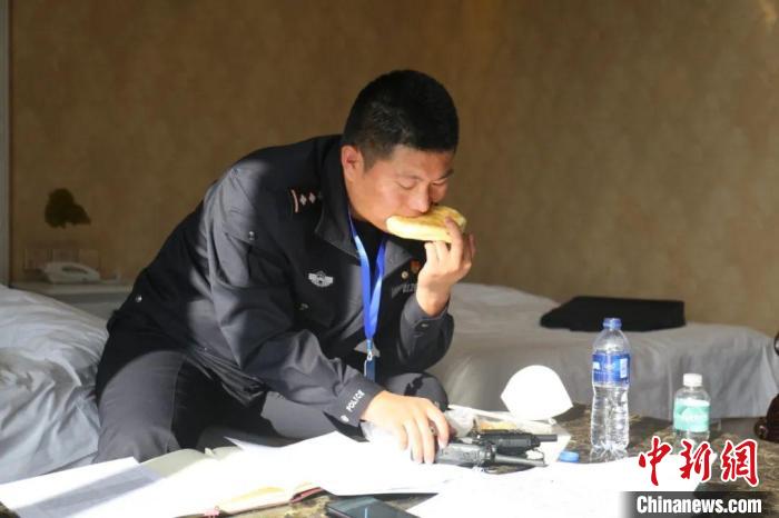 圖為李輝一邊吃飯一邊工作?！“蕉疾既?攝