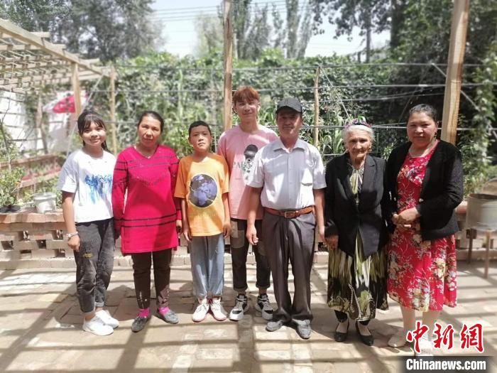 108歲老人努爾·依地?zé)崴?右二)喜愛勞作，澆花，喂羊，烤包子等都親力親為。圖為老人與部分子孫。　朱景朝 攝