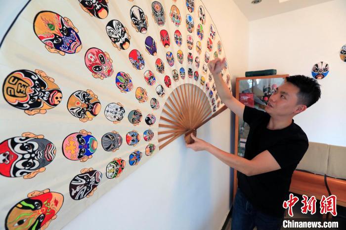熊啟在1.8米的折扇上繪制了75張不重樣的川劇臉譜。　王磊 攝