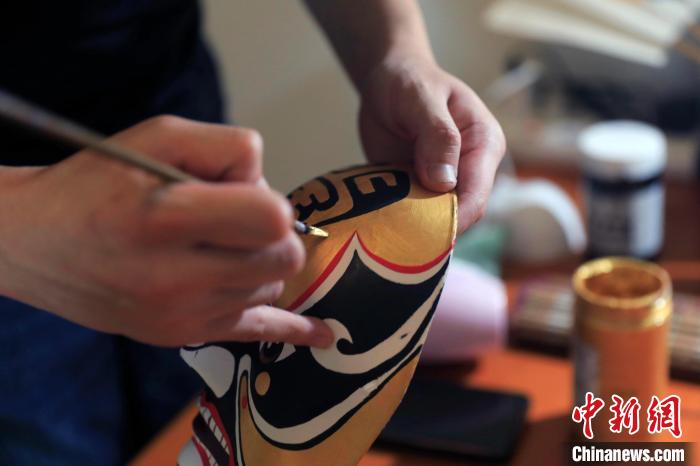 熊啟正在繪制川劇《唐王游地府》秦廣王的臉譜。　王磊 攝