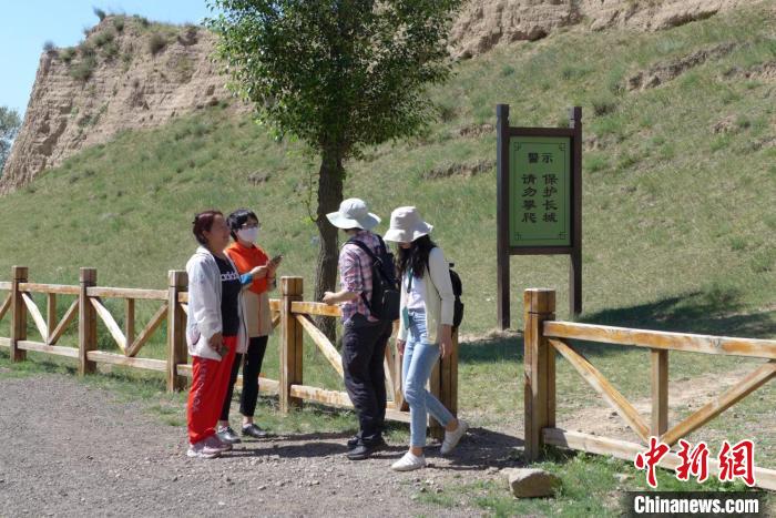 在巡查長城中，袁建琴為游客講解如何保護(hù)長城。袁建琴 供圖 受訪者袁建琴供圖