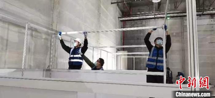 圖為工人搭建方艙醫(yī)院現(xiàn)場(chǎng)?！《毠﹫D