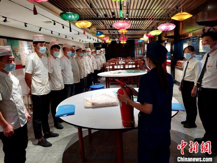 檢查期間，消防協(xié)管員為一家飯店后廚工作人員普及消防知識(shí)?！垘泿?攝