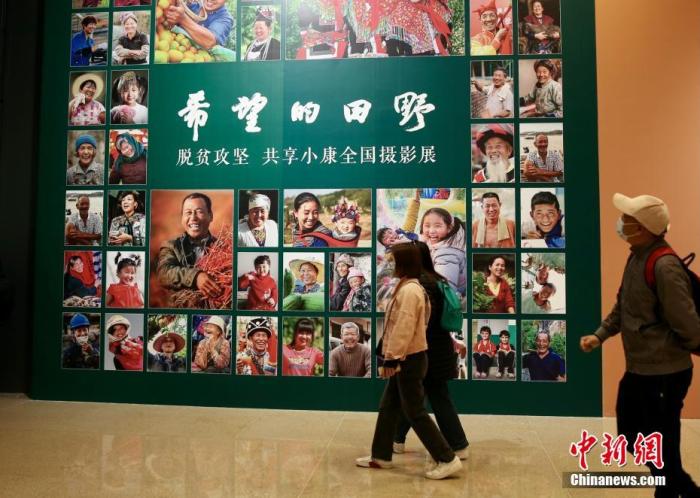 4月9日，由中國文學(xué)藝術(shù)界聯(lián)合會(huì)、中國國家博物館和中國攝影家協(xié)會(huì)聯(lián)合主辦的“希望的田野——脫貧攻堅(jiān) 共享小康全國攝影展”在國家博物館南廳正式開幕。本次展覽通過不同時(shí)期近150名攝影家的近180幅作品，生動(dòng)記錄脫貧攻堅(jiān)這一偉大歷史實(shí)踐，以影像的力量展示和反映全面建成小康社會(huì)取得的偉大成就。展覽共分為攻堅(jiān)與圓夢(mèng)兩個(gè)部分，包含產(chǎn)業(yè)扶貧、就業(yè)扶貧、異地搬遷扶貧、教育扶貧、文化扶貧等內(nèi)容。圖為觀眾進(jìn)入展廳參觀展覽。<a target='_blank' href='/'>中新社</a>記者 易海菲 攝