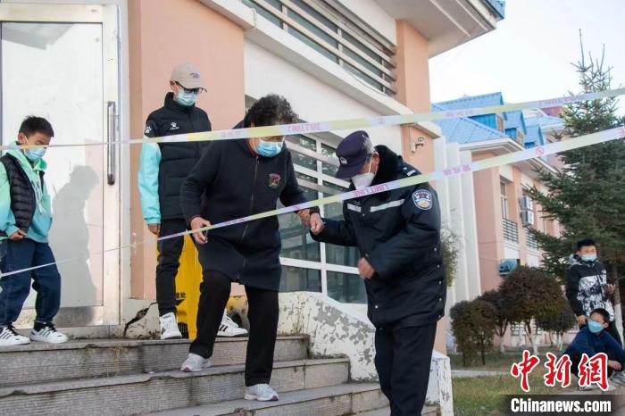 圖為王福幫助居民下樓梯?！∈?攝