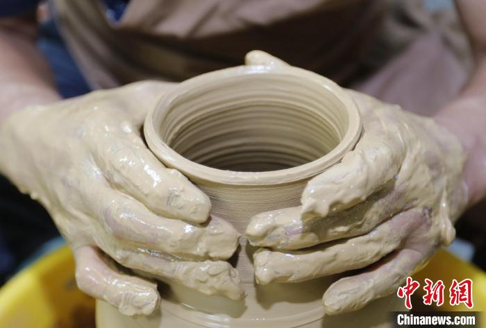 圖為張明正在進(jìn)行創(chuàng)意陶藝的定形工序?！￠T叢碩 攝