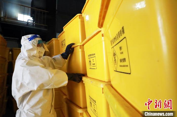 圖為工作人員搬運(yùn)醫(yī)療廢物專用周轉(zhuǎn)箱?！∥航ㄜ?攝