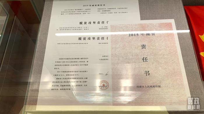 △“奮進新時代”主題成就展上陳列的“五級減貧責(zé)任狀”。(總臺央視記者范一鳴拍攝)