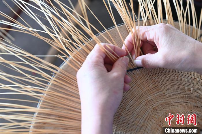 工匠正在編織花竹帽。　王以照 攝