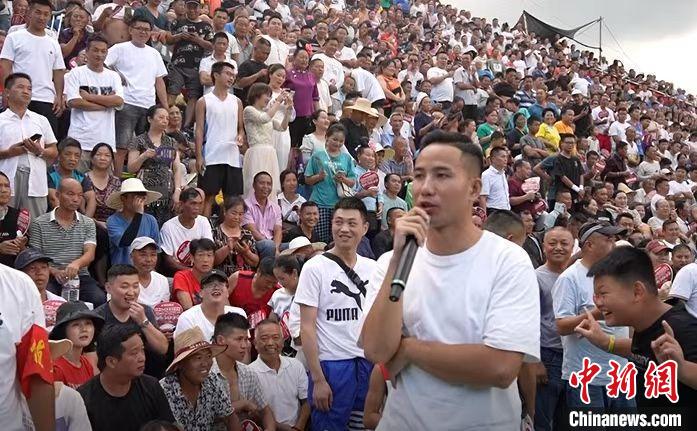 圖為臺(tái)盤村村民王再貴擔(dān)任球賽解說。　袁超 攝