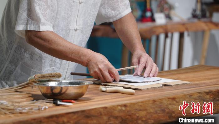 黃碩夫正在粘貼扇面?！±顙申?攝