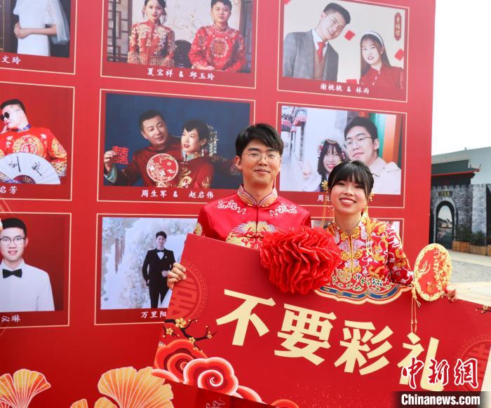 圖為參加“不要彩禮要幸?！奔w婚禮的新人在合影留念?！⒂駶?攝