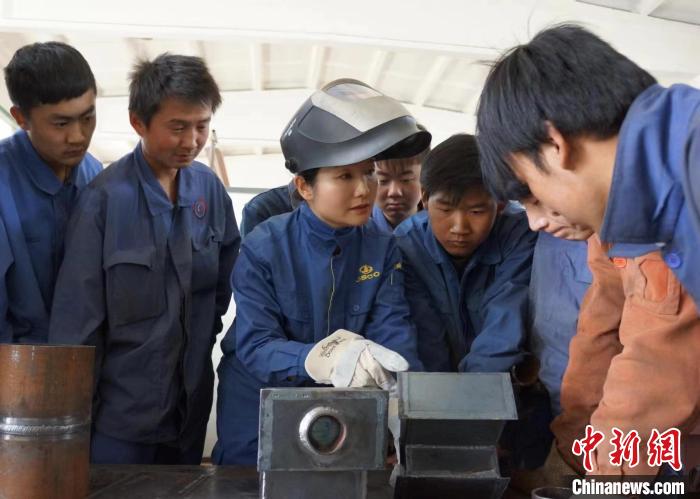 圖為呂杰(左三)給徒弟講解焊接技能操作。(資料圖) 受訪者供圖