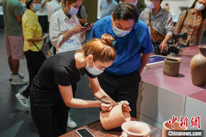 境外媒體代表在坭興陶制品上刻字。　陳冠言 攝