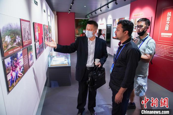 圖為外國(guó)青年傾聽了解黃文秀事跡。　陳冠言 攝