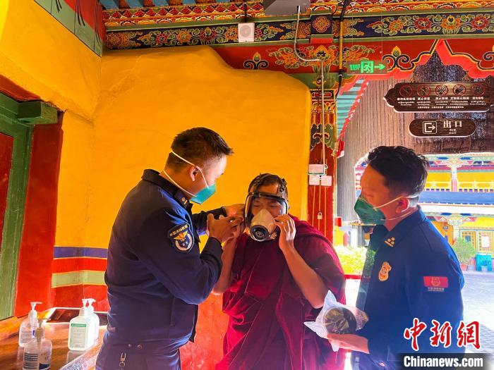 圖為消防員指導(dǎo)僧人學(xué)習(xí)佩戴防煙防毒面具?！±_市消防救援支隊供圖