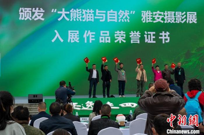 嘉賓為攝影展入選作者頒發(fā)證書?！⒅铱?攝