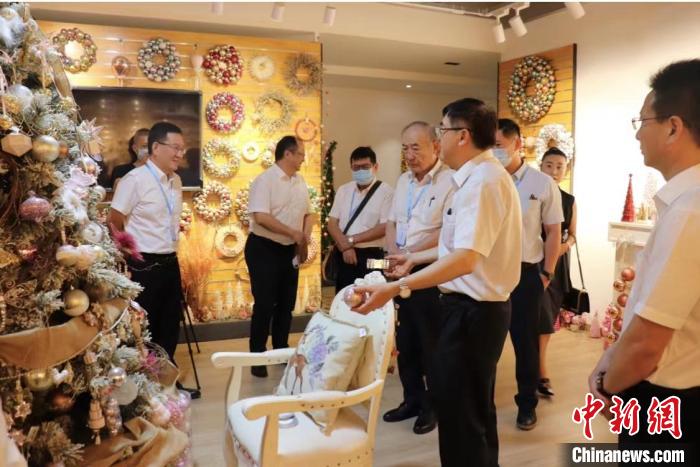 吳發(fā)彬向參觀者介紹圣誕節(jié)產(chǎn)品?！∈茉L者供圖