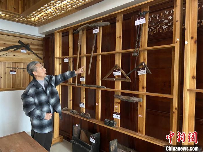 圖為葉偉平向前來參觀的民眾介紹修復(fù)古建筑時使用的工具。　劉玉潔 攝