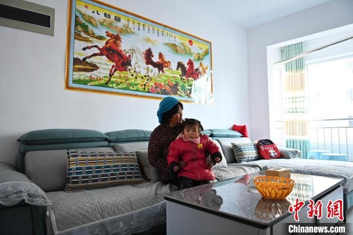 12月5日，宕昌縣哈達(dá)鋪鎮(zhèn)生態(tài)及地質(zhì)災(zāi)害避險(xiǎn)搬遷集中安置點(diǎn)內(nèi)，已搬遷居民與孫女閑坐。　李亞龍 攝