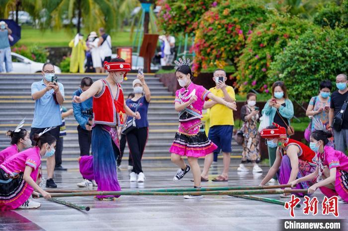 資料圖：三亞大小洞天旅游區(qū)入口，工作人員跳竹竿舞迎接游客?！●樤骑w 攝