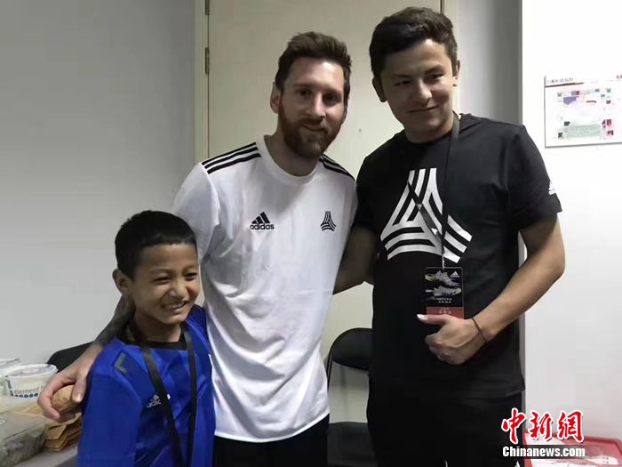 阿布都拉哈力克·艾木杜拉和他的體育老師在北京，與梅西合影。葉城縣教委供圖