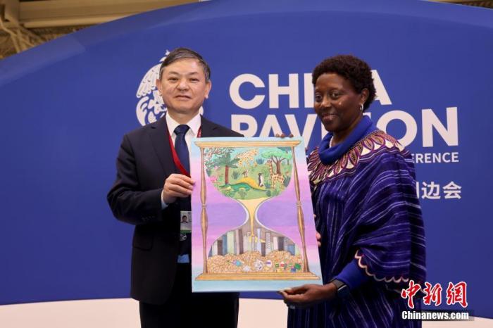 當(dāng)?shù)貢r(shí)間12月11日，在加拿大蒙特利爾舉行的《生物多樣性公約》第十五次締約方大會(huì)(COP15)第二階段會(huì)議會(huì)場內(nèi)，COP15主席、中國生態(tài)環(huán)境部部長黃潤秋向《生物多樣性公約》秘書處執(zhí)行秘書穆雷瑪贈(zèng)送了以保護(hù)生物多樣性為主題的“多彩世界”國際青少年繪畫邀請展的中國青少年優(yōu)秀作品。 <a target='_blank' href='/'>中新社</a>記者 余瑞冬 攝