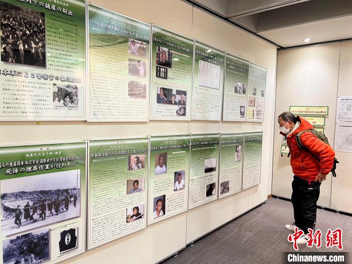 日本侵華戰(zhàn)爭圖片展12日至18日在日本東京舉行。圖為日本民眾參觀圖片展?！≈斐筷?攝