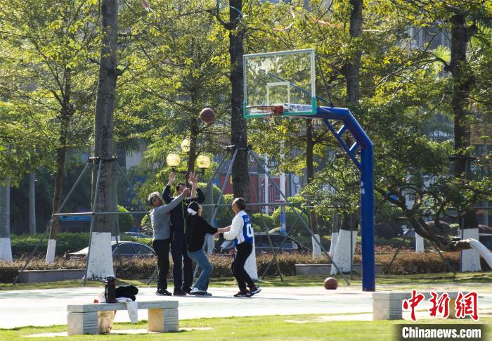 圖為市民、游客在防城港市公園廣場打籃球?！〉岳顝?qiáng) 攝