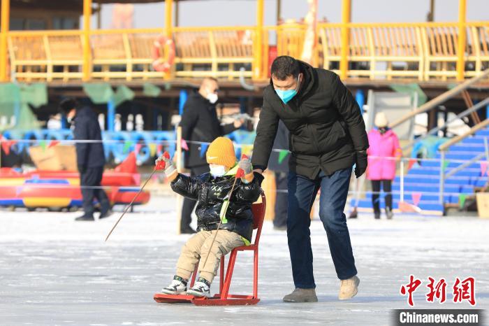 游客們體驗(yàn)冰上爬犁?！『嚏?攝
